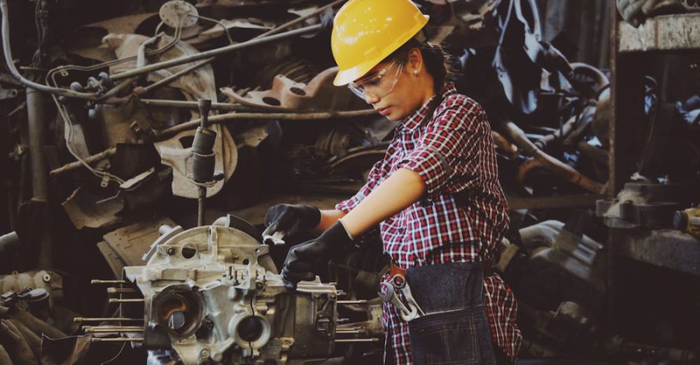 Skills - Woman Wears Yellow Hard Hat Holding Vehicle Part