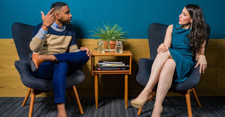 Talks - Woman Wearing Teal Dress Sitting on Chair Talking to Man