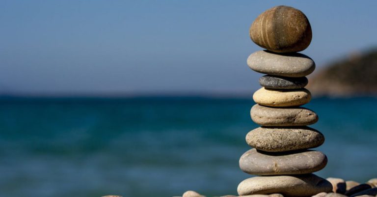 Balance - Cairn Stones and Body of Water in Distance